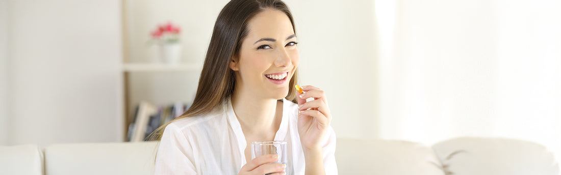 Frau nimmt Omega 3 Kapsel zur Unterstützung beim Abnehmen