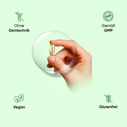Vegane Omega-3 Kapsel in Hand, transparente Kugel mit goldener Kapsel